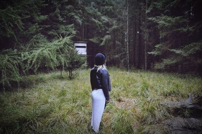 Rear view of woman standing on grassy field