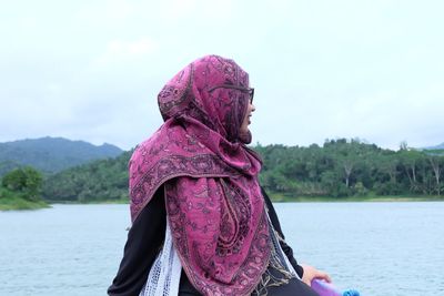 Smiling woman sitting on boat in river against sky