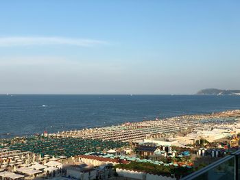 High angle view of townscape by sea against sky