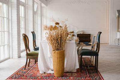 Table set for thanksgiving with vintage chairs of different shapes and colors in a bright living