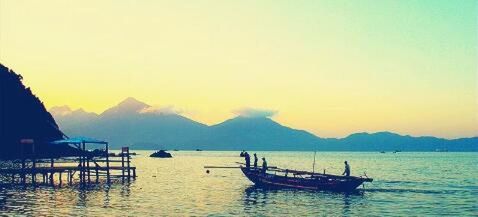 Boats in sea at sunset