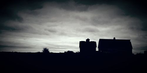 Low angle view of silhouette built structure against sky