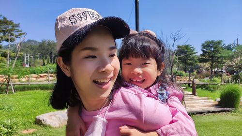 Portrait of smiling girl with mother at park