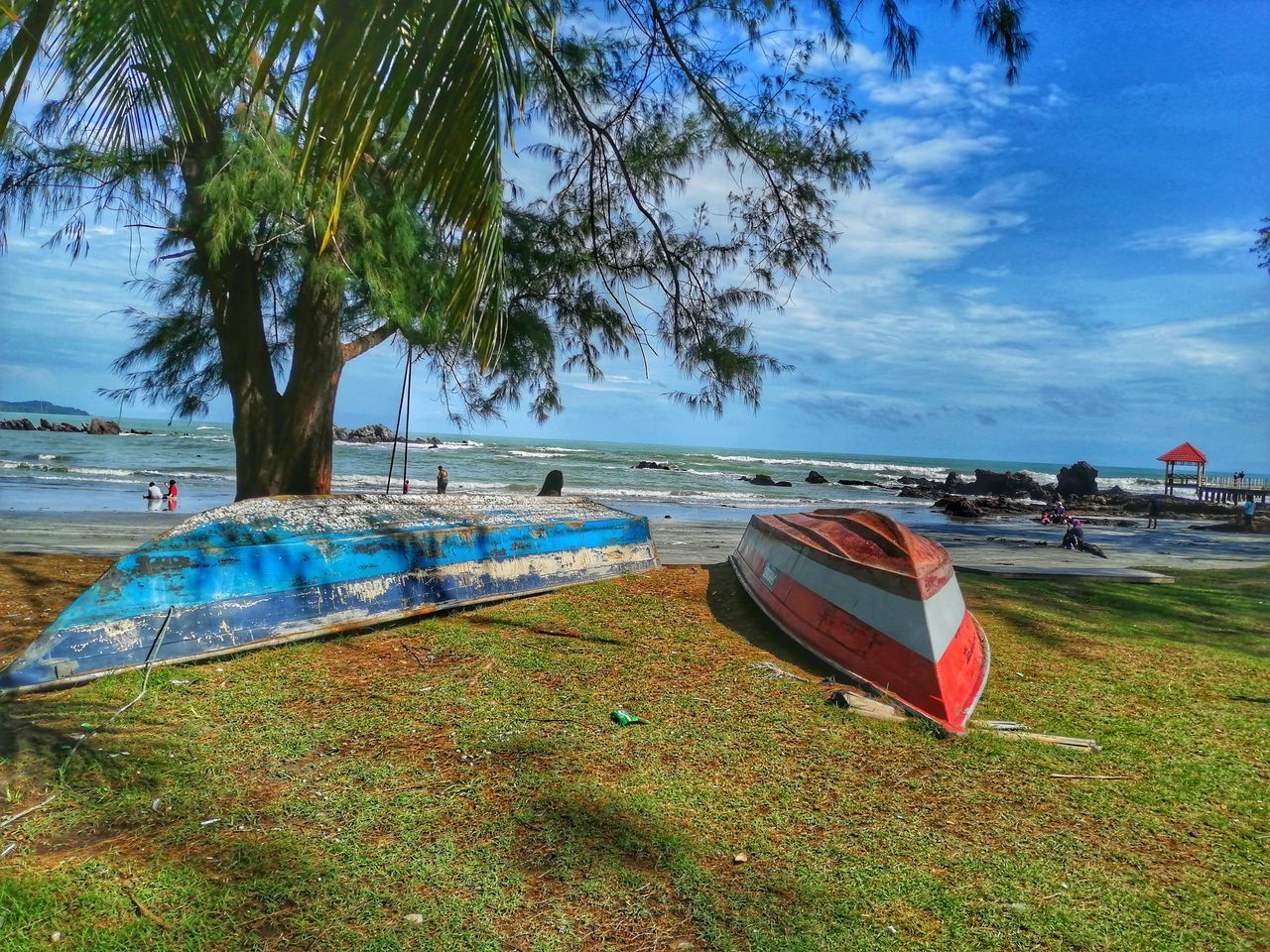 BOATS MOORED ON SHORE AGAINST SKY