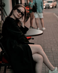 Young woman sits near restaurant 