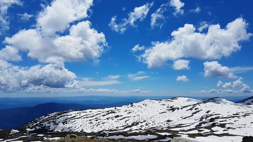 Scenic view of snowcapped mountains against blue sky