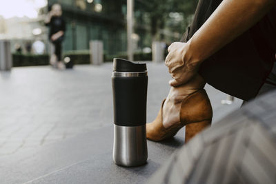 Low section of businesswoman touching ankle