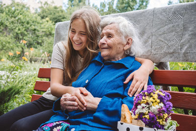 Grandparents day, reunited family, togetherness. senior old grandma hugs granddaughter outdoors