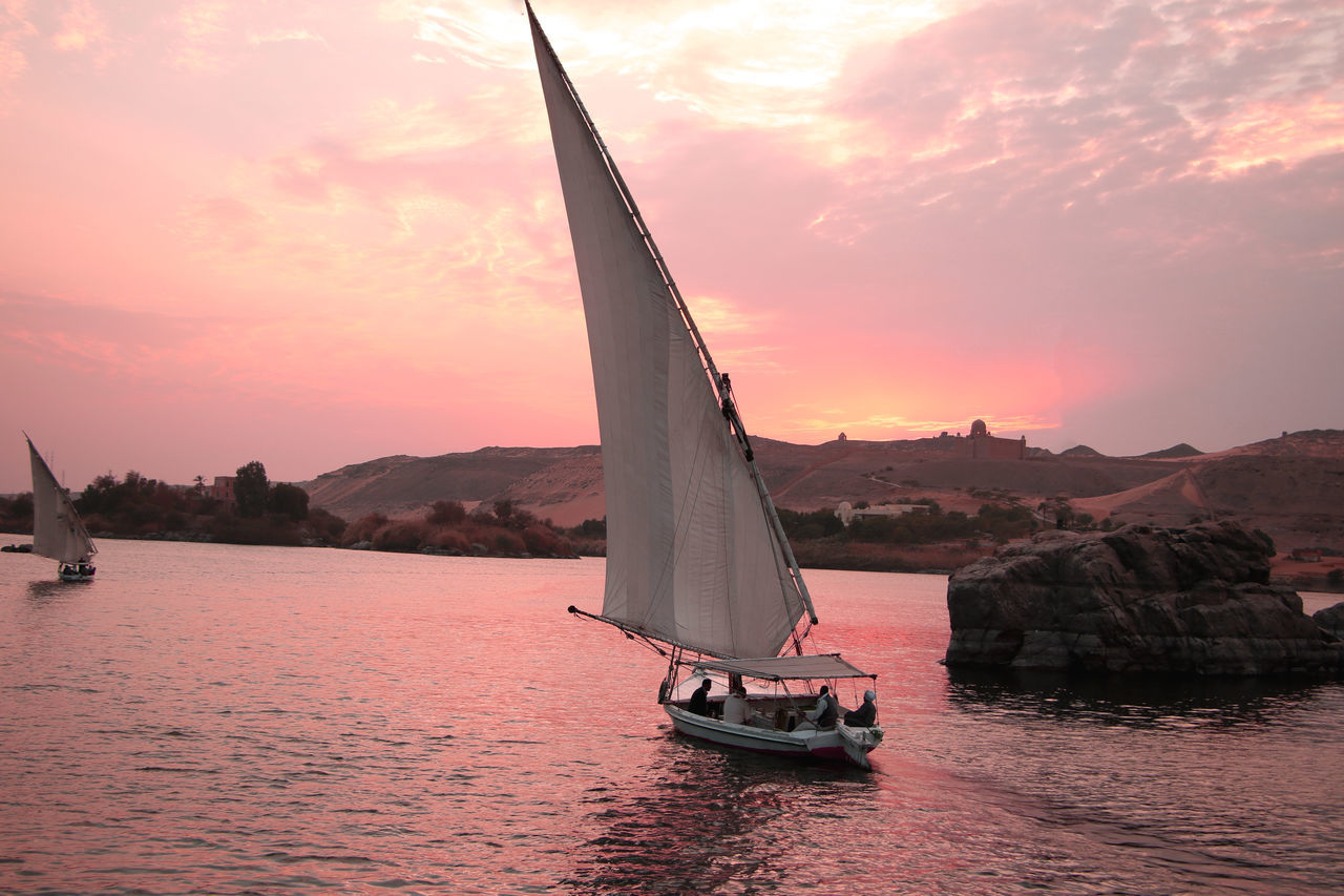 NAUTICAL VESSEL SAILING ON SEA AGAINST SKY DURING SUNSET