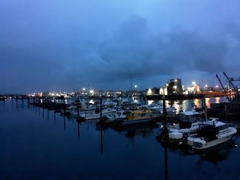 Sailboats moored in harbor at night