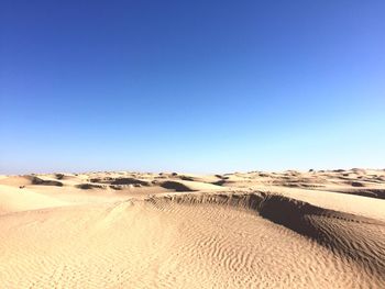 View of desert against clear blue sky