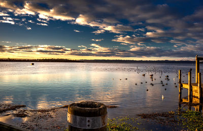 Scenic view of the lake against the sky at sunset