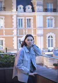 Young woman standing against building