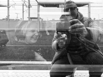 Portrait of man photographing through car window