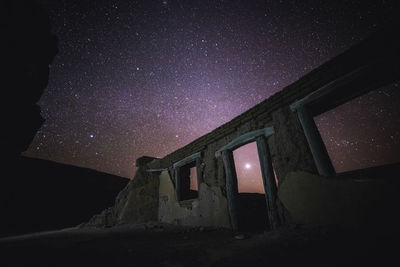 Low angle view of abandoned house against sky at night