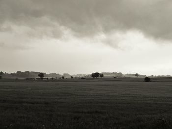 Scenic view of grassy field against cloudy sky