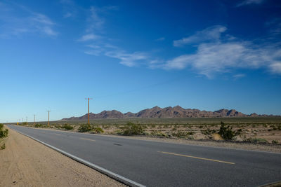 Empty road along countryside landscape