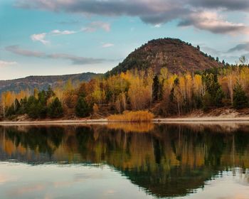 Scenic view of lake by trees against sky