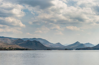 Scenic view of lake by mountains against sky