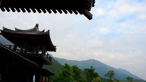 Low angle view of temple and building against sky