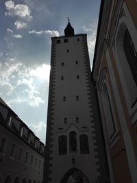 Low angle view of clock tower amidst buildings against sky