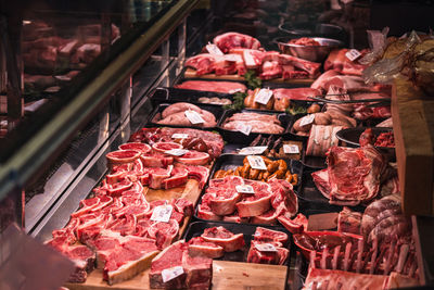 Fresh meat cuts on display at vibrant food market butcher stall with variety options