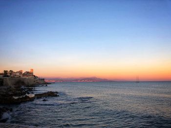 Scenic view of sea against clear sky during sunset