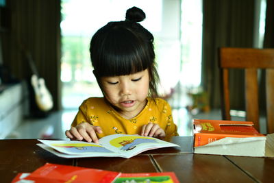 Cute girl reading book at home