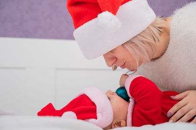 Mother wearing santa hat embracing baby