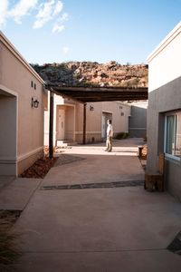 Woman outside house against sky in city