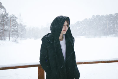 Woman standing on snow covered landscape