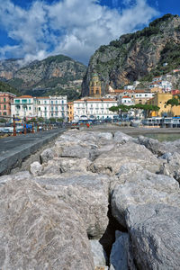 Town by sea and mountains against sky