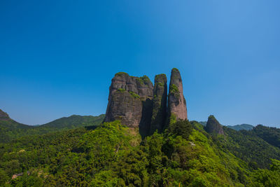 Low angle view of rock formations against blue sky