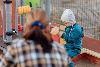 A boy, person with down syndrome walks in the park with his mother