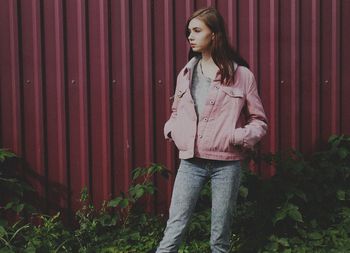 Thoughtful young standing against corrugated wall