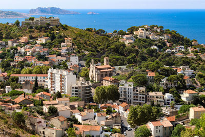 High angle view of townscape by sea against sky