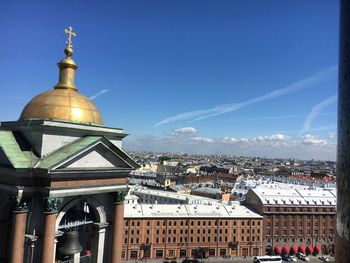 Buildings in city against blue sky