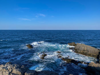 Scenic view of sea against blue sky