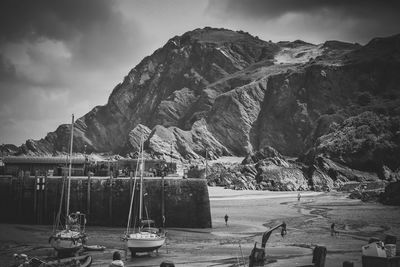 Boats moored at beach against mountain