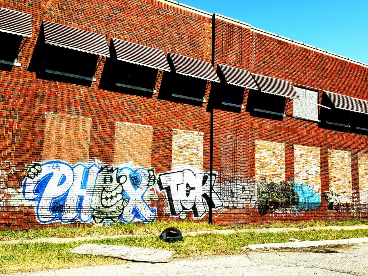 building exterior, architecture, built structure, house, clear sky, wall - building feature, brick wall, residential structure, window, blue, graffiti, sunlight, day, building, outdoors, residential building, pattern, no people, old, low angle view