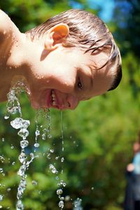 Water spraying on smiling boy