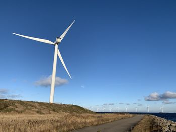 Windmill on field against sky, danish energy innovation. 