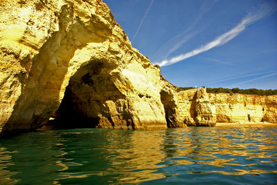 Rock formation in sea against sky