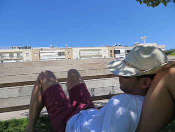 Low section of man wearing shoes against clear sky