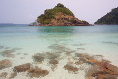 Scenic view of rocks on beach against sky