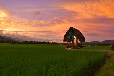 Built structure on field against sky during sunset