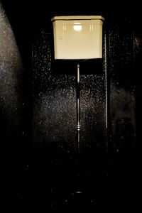 Close-up of illuminated light bulb against wall