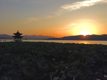 Scenic view of west lake against sky during sunset