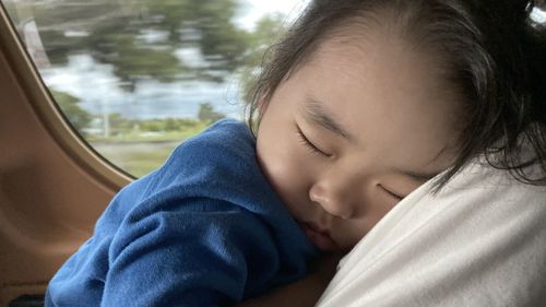 Close-up portrait of boy sleeping in car