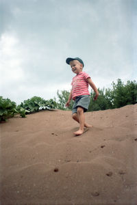 A boy runs through the sand